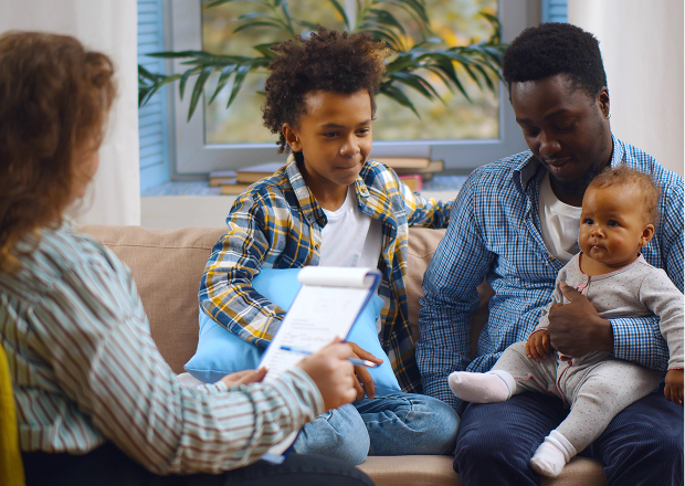 A parent with two children meeting with a caseworker